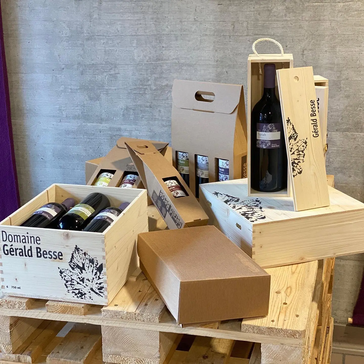 Assortiment de coffrets cadeaux pour bouteilles de vin du Domaine Gérald Besse (Valais, Suisse) : caisses en bois gravées et étuis en carton pour 1, 2 ou 6 bouteilles.